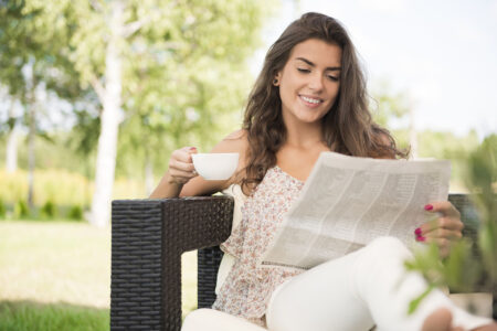 Femme lisant un journal papier fabriqué par Norske Skog Golbey